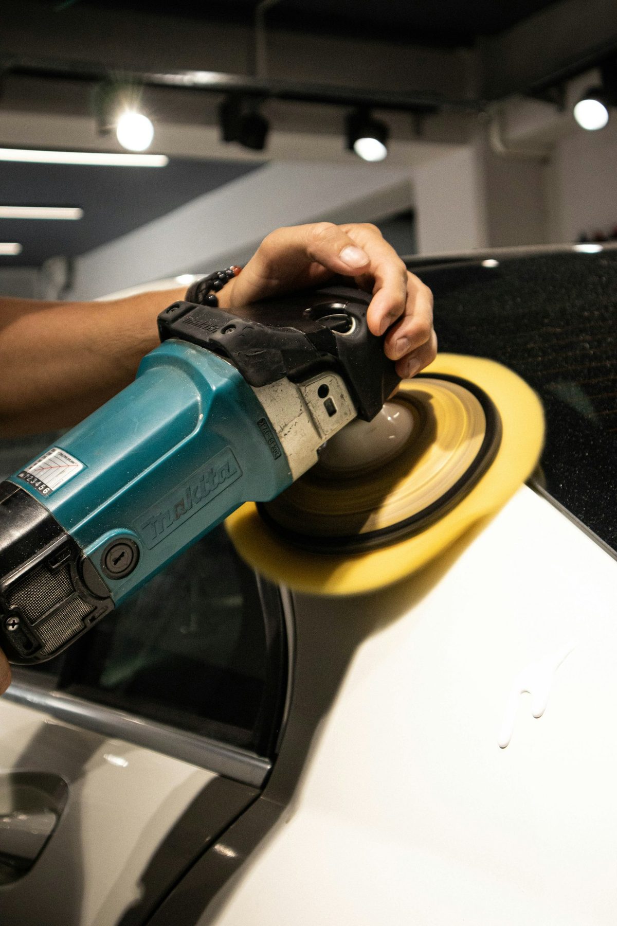 Machine polishing a car's paint during a Pro Package detail